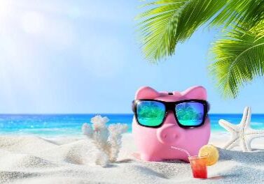 A pink piggy bank sitting on top of the beach.